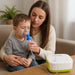 Woman holding a child using an inhaler with a Dr. Olof device on a table.