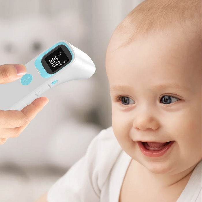 Baby being measured with a digital thermometer, with a blurred background